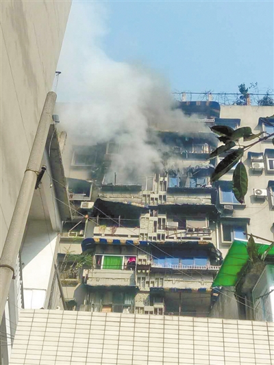 昨日,沙坪坝三角碑附近,失火的居民楼腾起滚滚浓烟.